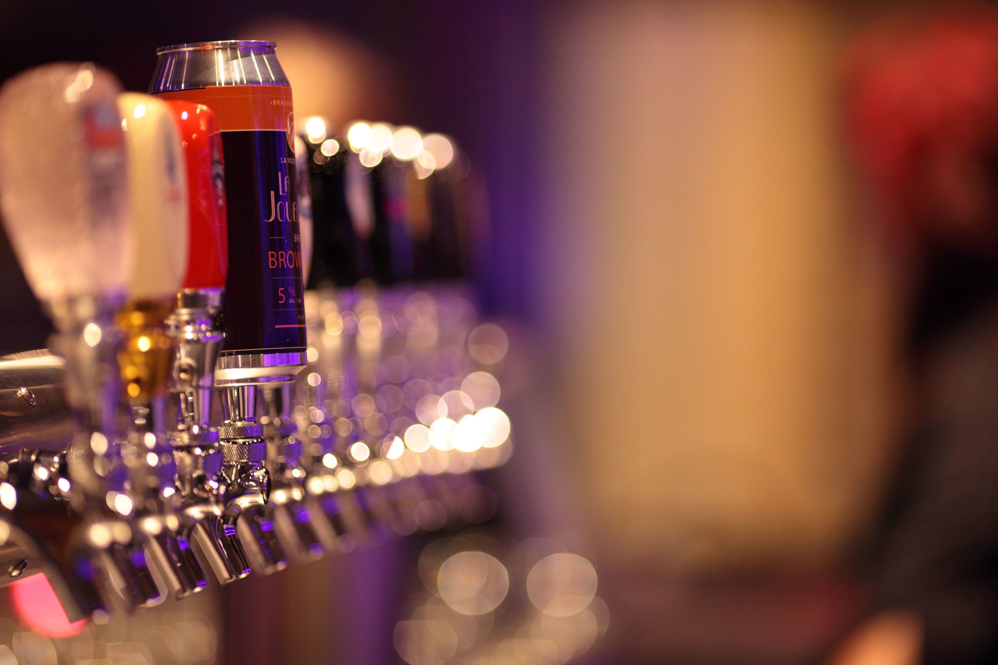 A bar with various bottles and cans, including a prominent red bottle and a blue can.