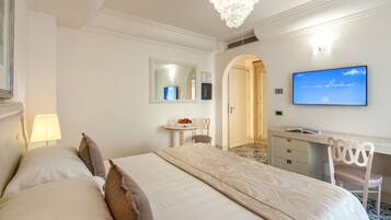 Une chambre d’hôtel avec un grand lit, un bureau, une chaise, une télévision et un miroir.