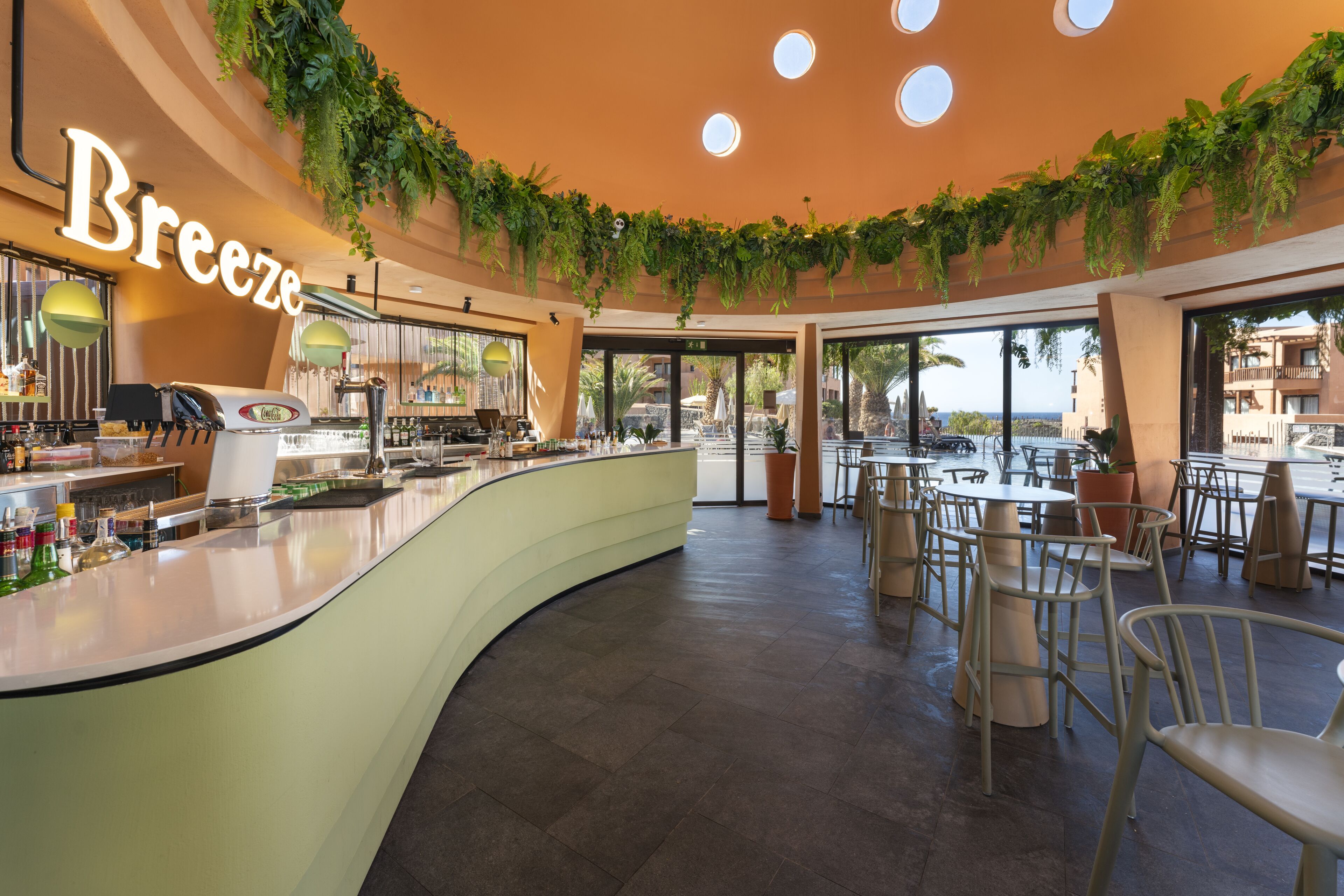 A cafe with a curved counter, a coffee machine, and a sign that reads "Breeze".