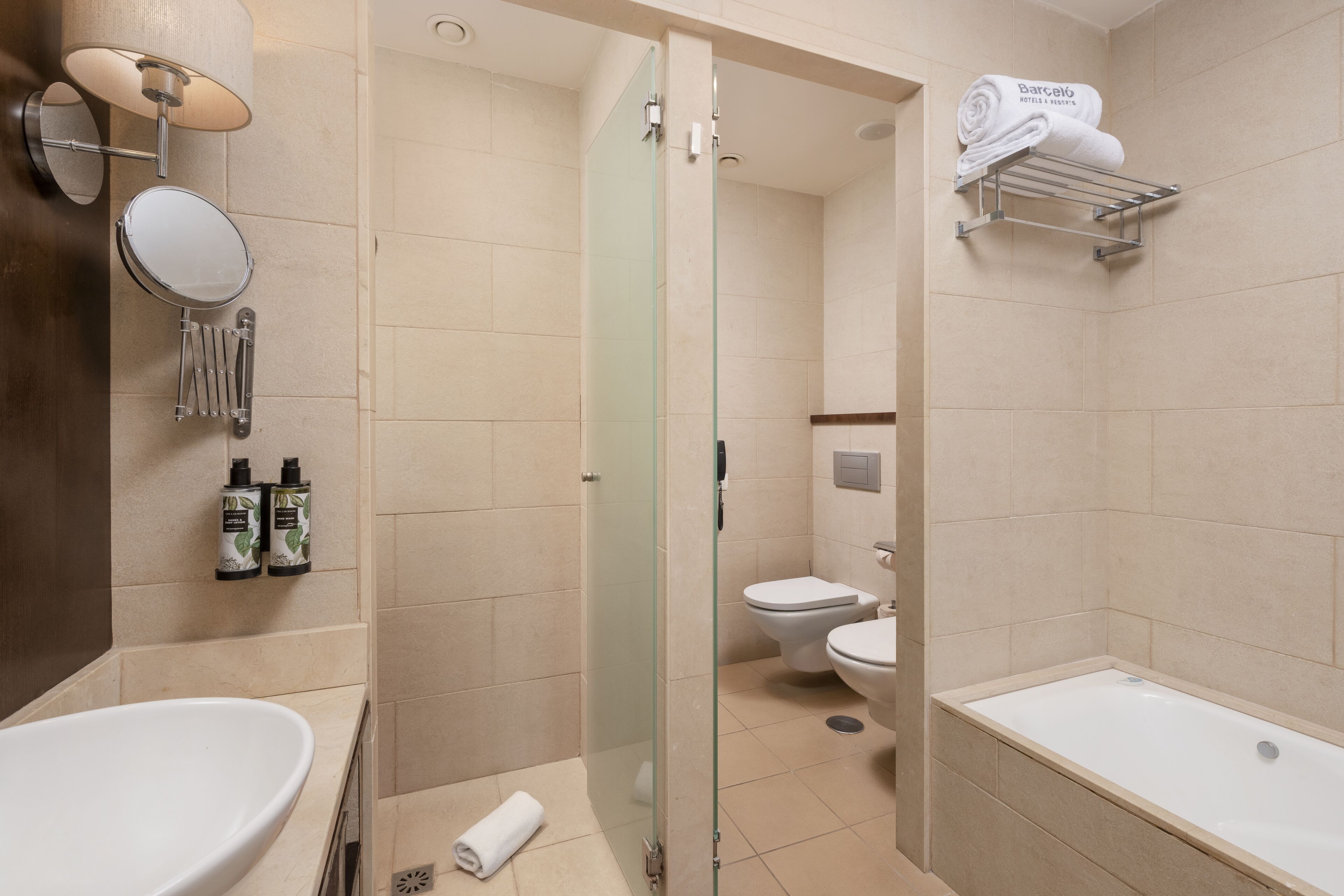 A modern bathroom with a glass-enclosed shower, a white sink, and a bathtub.