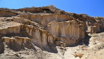 Eine zerklüftete, felsige Landschaft mit geschichteten Sedimentschichten.