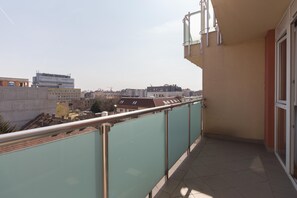 A balcony with a view of a cityscape, including buildings and a construction crane. - Premium Apartment House (Budapest)