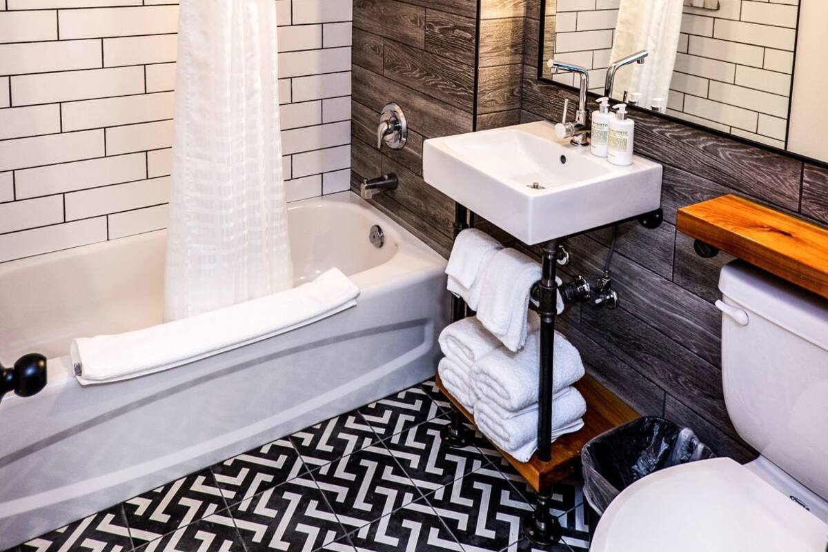 A bathroom with a bathtub, white sink, and toilet.