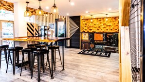 A bar area with stools, a wooden counter, and pendant lighting. - Crash Hotel Squamish (Squamish)