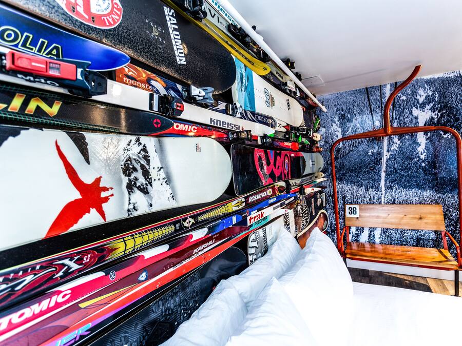 A ski-themed room with a wall decorated with various ski-related stickers and a ski lift chair.