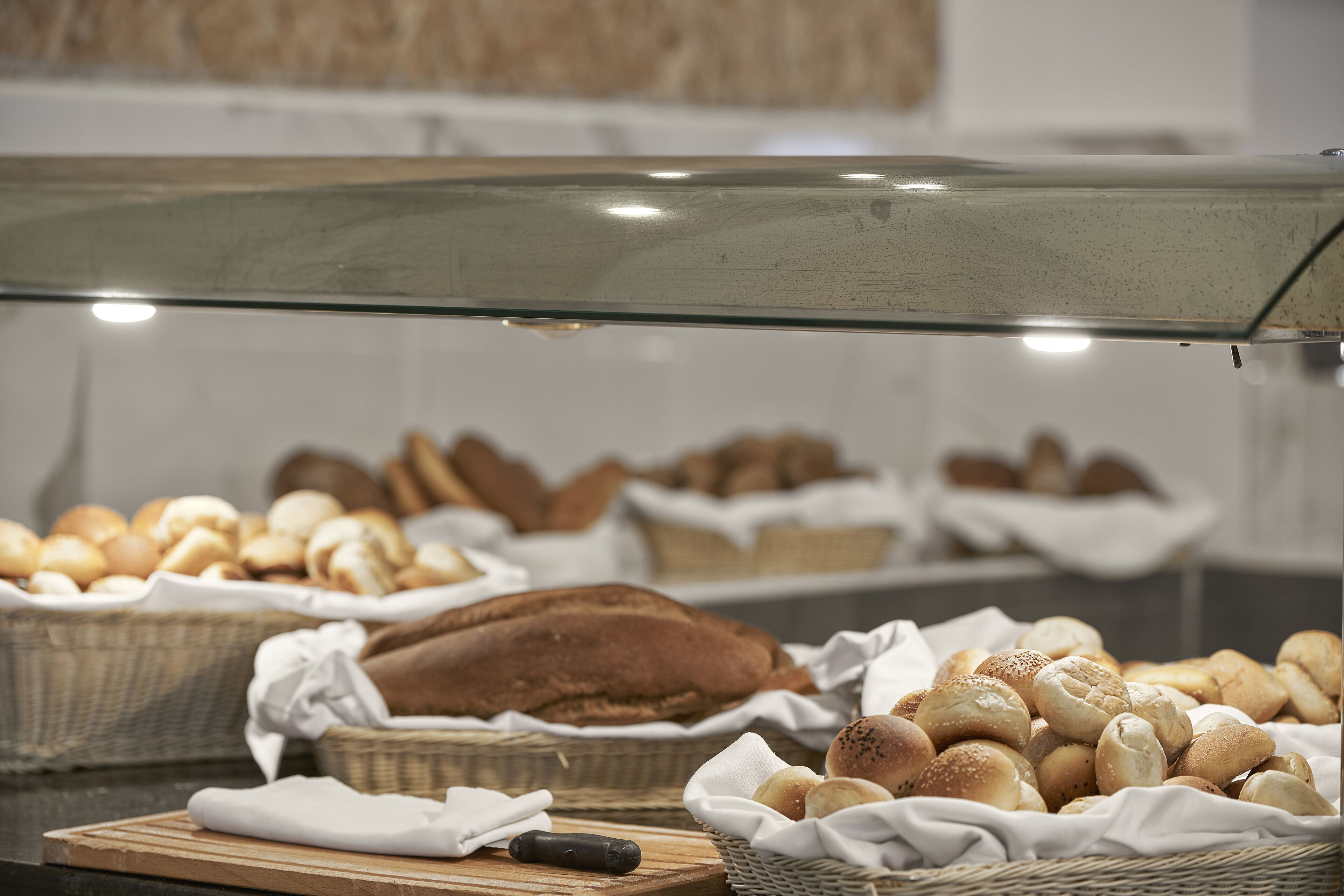 A bakery display case with various types of bread and pastries.
