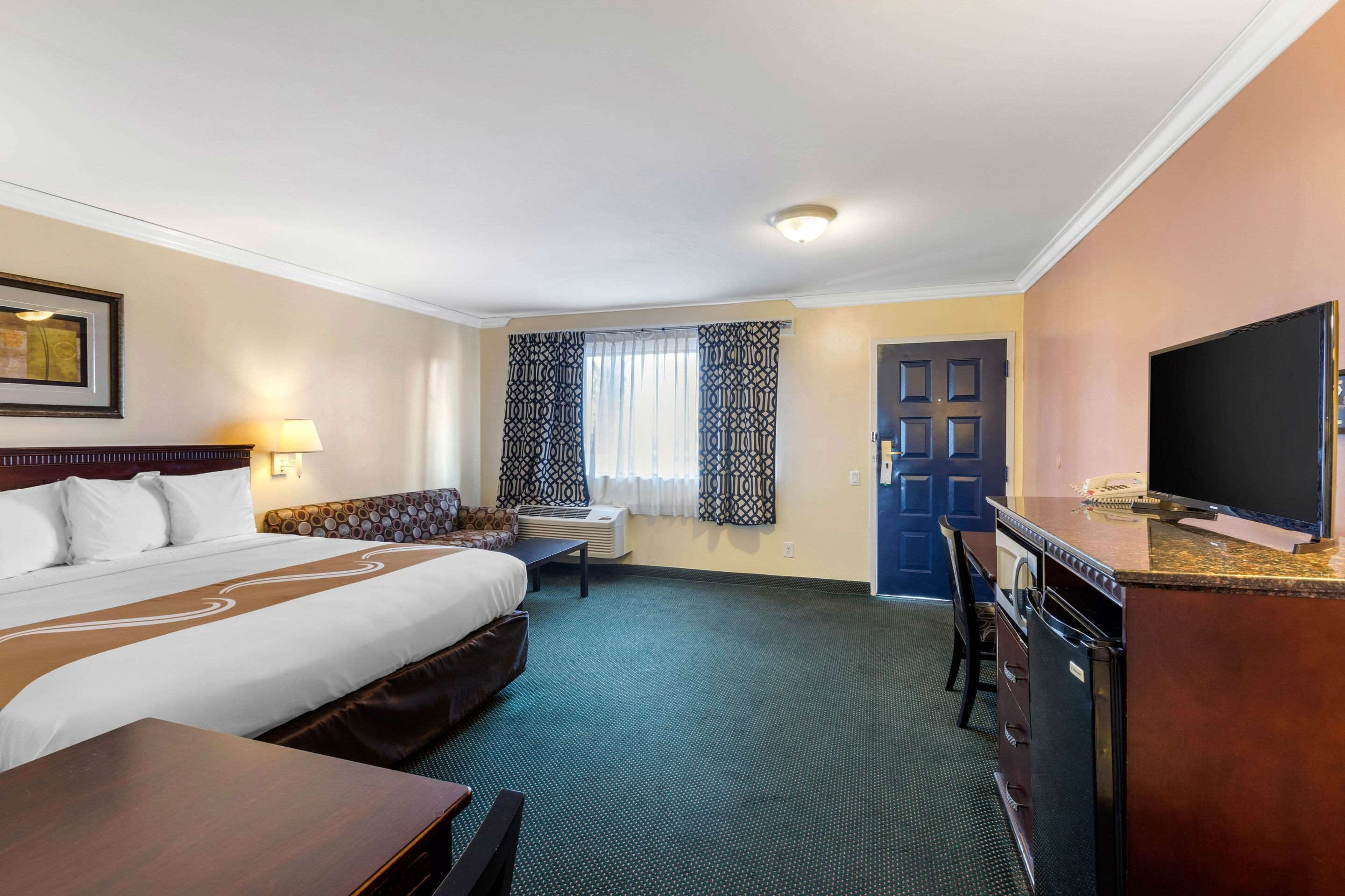 Premium bedding, desk, laptop workspace, blackout drapes