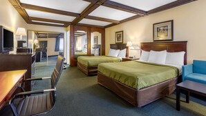 Une chambre d’hôtel avec deux lits, un bureau, une chaise et un téléviseur.