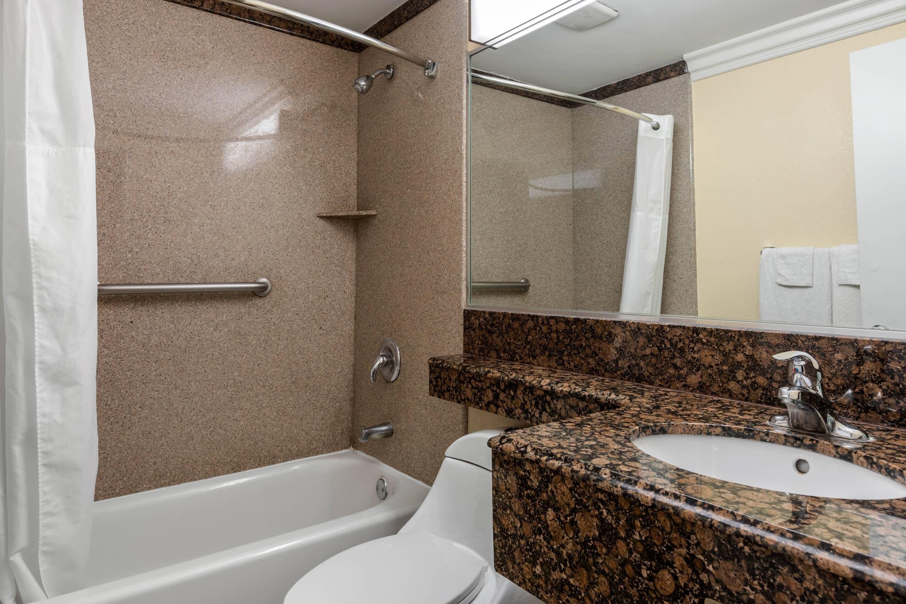 A bathroom with a bathtub, toilet, and sink.