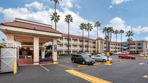 Un hôtel doté d’un parking, de plusieurs étages et de palmiers.