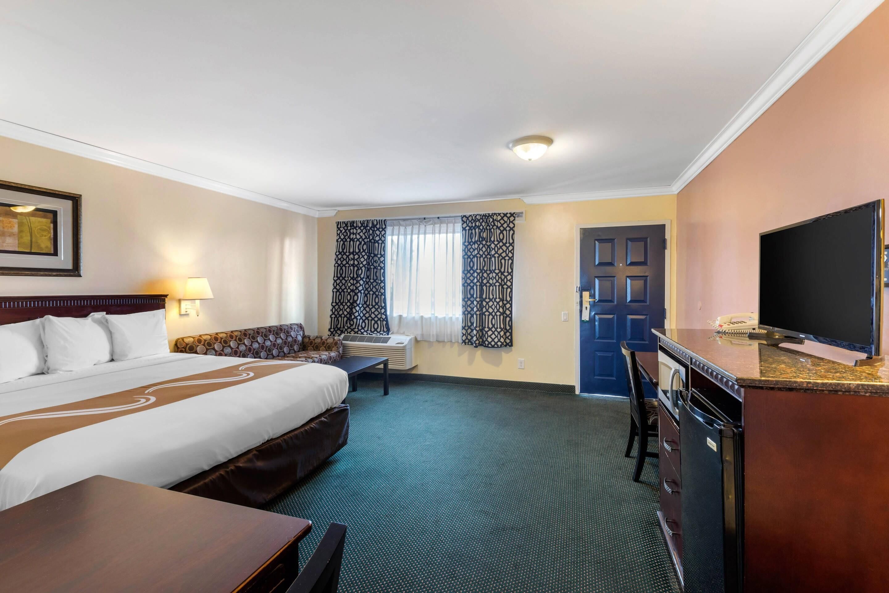 Premium bedding, desk, laptop workspace, blackout drapes