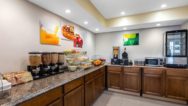 Une cuisine d’hôtel équipée d’un buffet pour le petit-déjeuner, d’un coin café et de différents distributeurs de nourriture.
