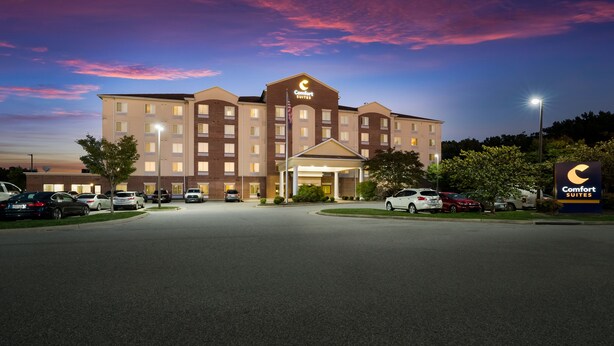 A Comfort Suites hotel with a large parking lot, multiple floors, and a well-lit entrance. - Comfort Suites Suffolk - Chesapeake (Suffolk)