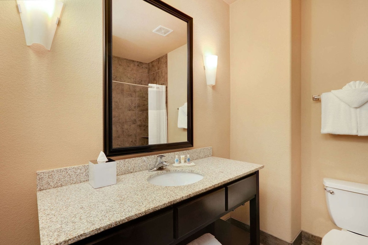 A bathroom with a sink, mirror, towel rack, and toilet.
