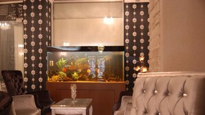 Un espace détente avec un grand aquarium, des sièges confortables et un mur décoratif.