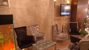 Un salon chaleureux avec un mur en briques, un téléviseur à écran plat et un sapin de Noël.