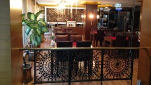 Un restaurant doté d’un plancher en bois, d’un lustre et d’un espace bar.