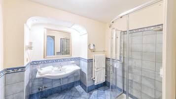 Un baño con lavamanos, espejo y ducha.