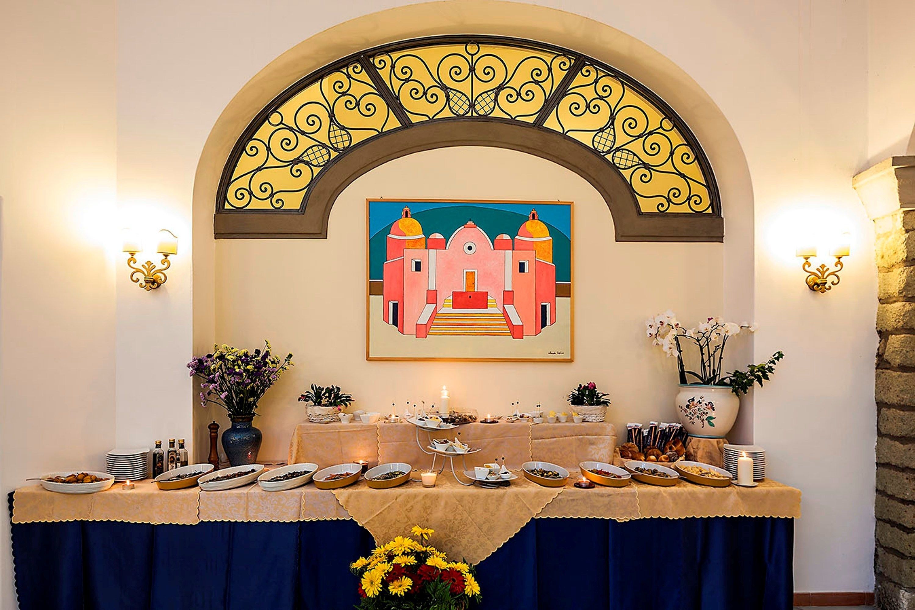 A buffet table with various dishes and a decorative archway above it.