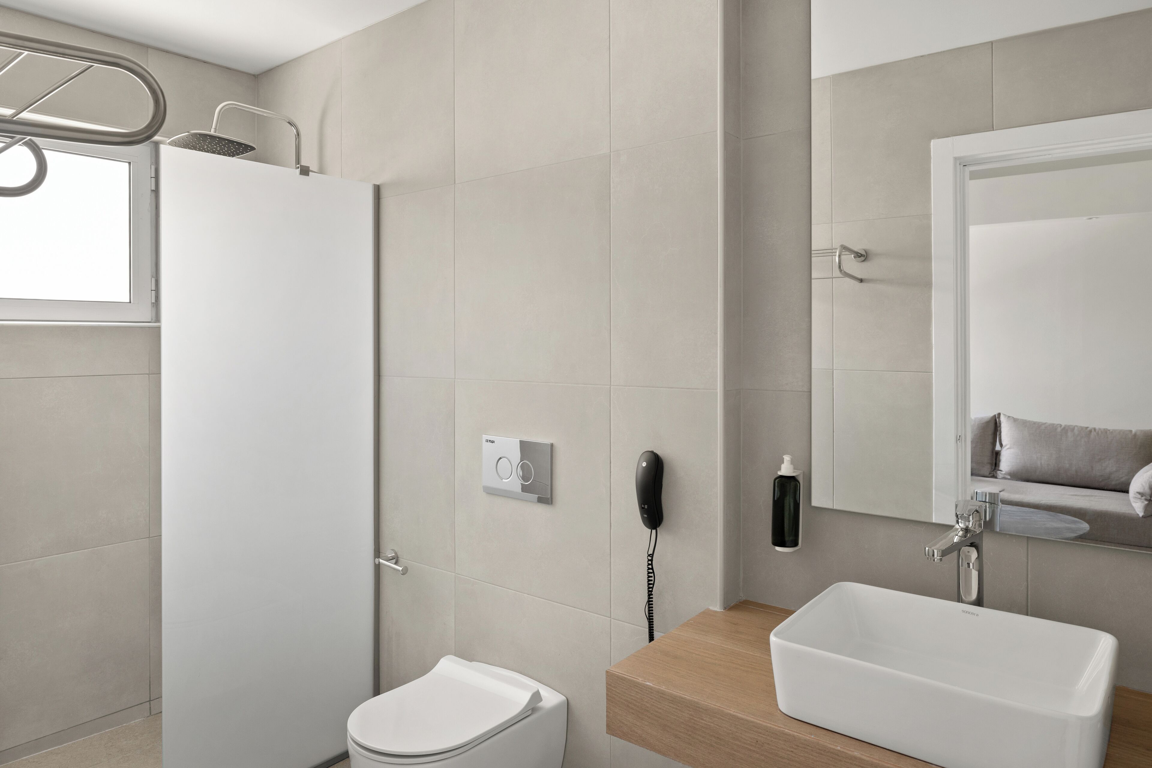 A modern bathroom with a toilet, shower, and sink.