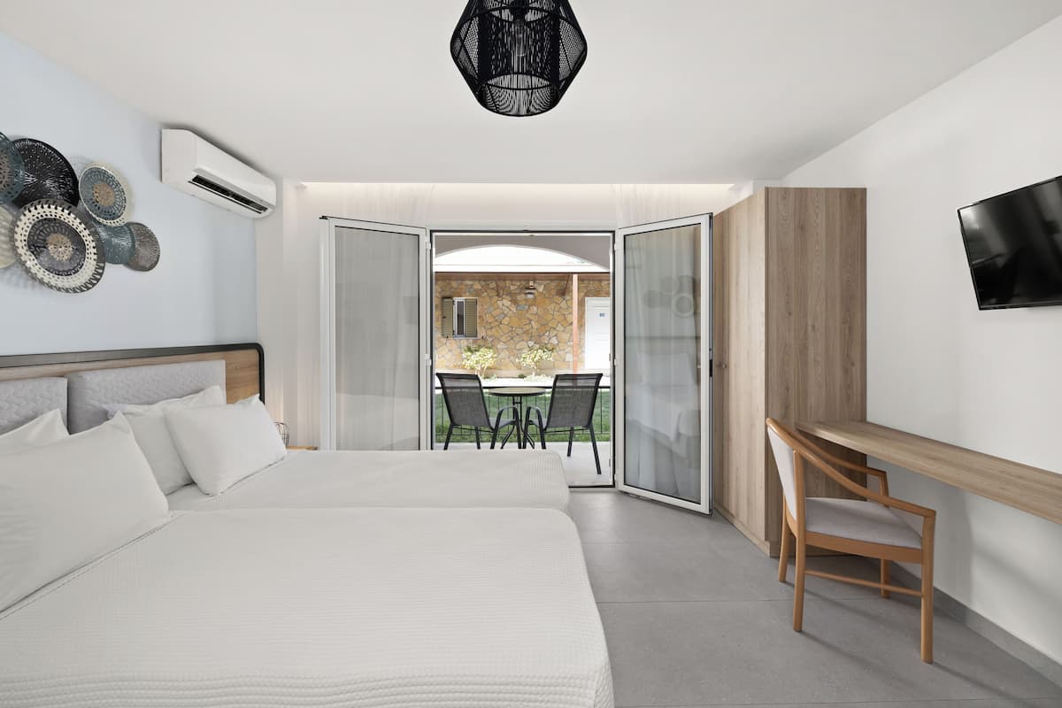 A modern hotel room with a large bed, a desk, and a TV.