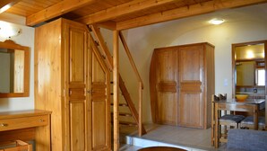 A wooden interior with a staircase, a dining area, and a seating area. - Anemomilos Suites (Santorini)