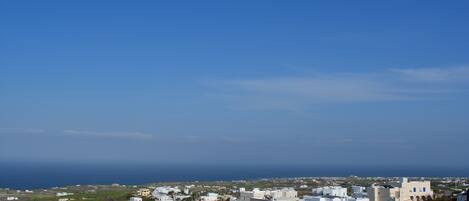 A coastal town with a variety of buildings, including residential and commercial structures, under a clear blue sky.