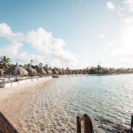 On the beach, white sand, beach cabanas, sun loungers