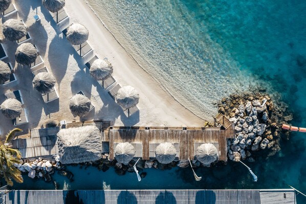 On the beach, white sand, beach cabanas, sun loungers