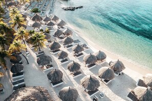 On the beach, white sand, beach cabanas, sun-loungers