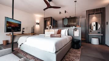 Un dormitorio moderno con una cama grande, ventilador de techo, televisión y pared decorativa de madera.