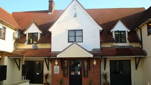 A two-story building with a sign reading "Welcome to The Bushell & Sack Hotel." - Stansted Skyline Hotel (Dunmow)