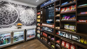 A snack and beverage display area with refrigerated cases and shelves stocked with various snacks and drinks. - Hampton Inn & Suites West Sacramento (West Sacramento)