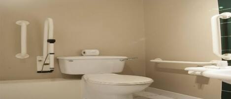 Une petite salle de bain propre, équipée de toilettes, d’un lavabo et d’un miroir.