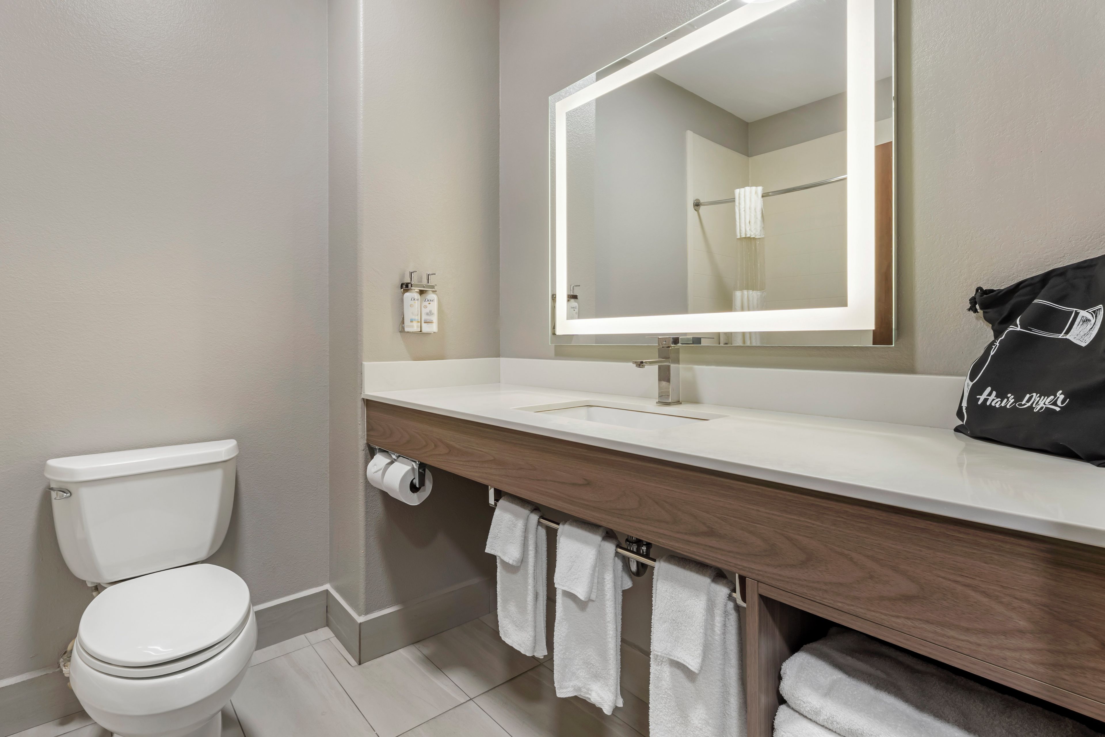 A bathroom with a toilet, a sink with a mirror, and a towel rack.