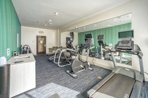 A fitness center with treadmills, elliptical machines, and a weight bench.