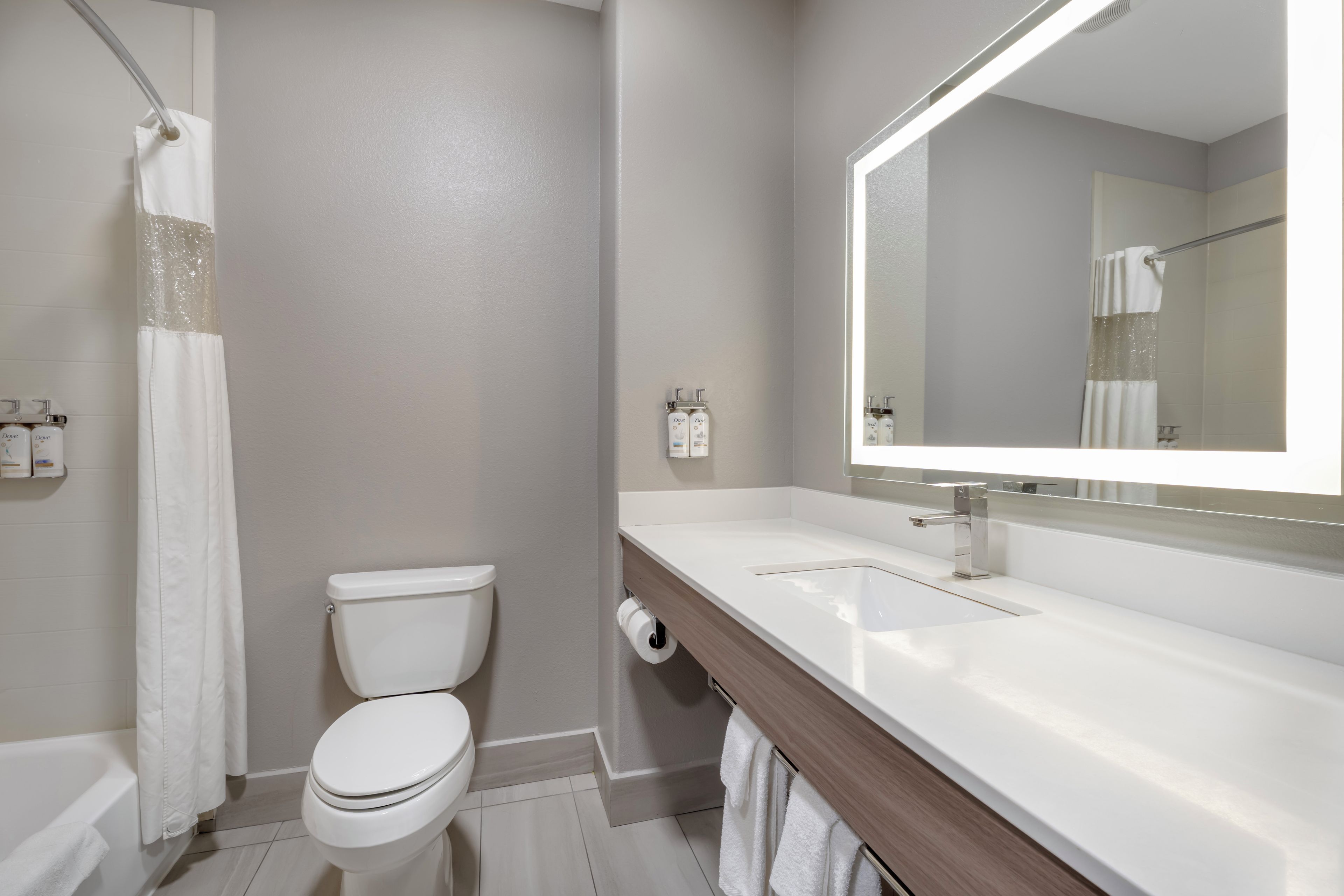 A modern bathroom with a toilet, sink, and shower.