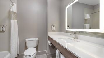 A modern bathroom with a toilet, sink, and shower.