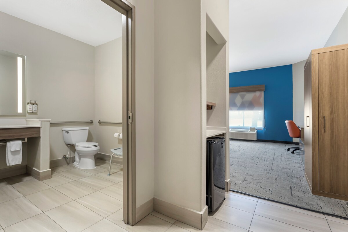 A modern bathroom with a toilet, sink, and shower area.
