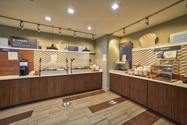 A modern breakfast area with an express breakfast counter, a bakery section, and a fruit display. - Holiday Inn Express Suites Beeville by IHG (Beeville)