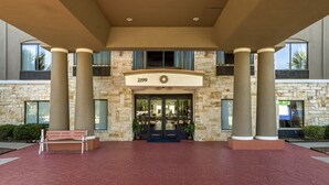 A building entrance with a stone facade, large columns, and a number '2199' above the doors. - Holiday Inn Express Suites Beeville by IHG (Beeville)