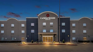 Un hotel con una entrada destacada, una bandera y un cielo despejado.