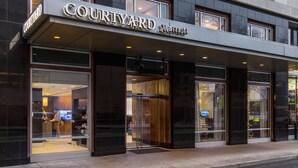 A Courtyard Marriott hotel entrance with a modern facade, large glass doors, and a visible reception area inside. - Courtyard by Marriott Portland City Center (Portland)
