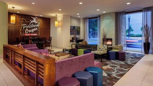 A lobby with a reception desk, seating area, and a fireplace. - Courtyard by Marriott Portland City Center (Portland)