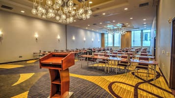 A conference room with tables, chairs, and a podium.