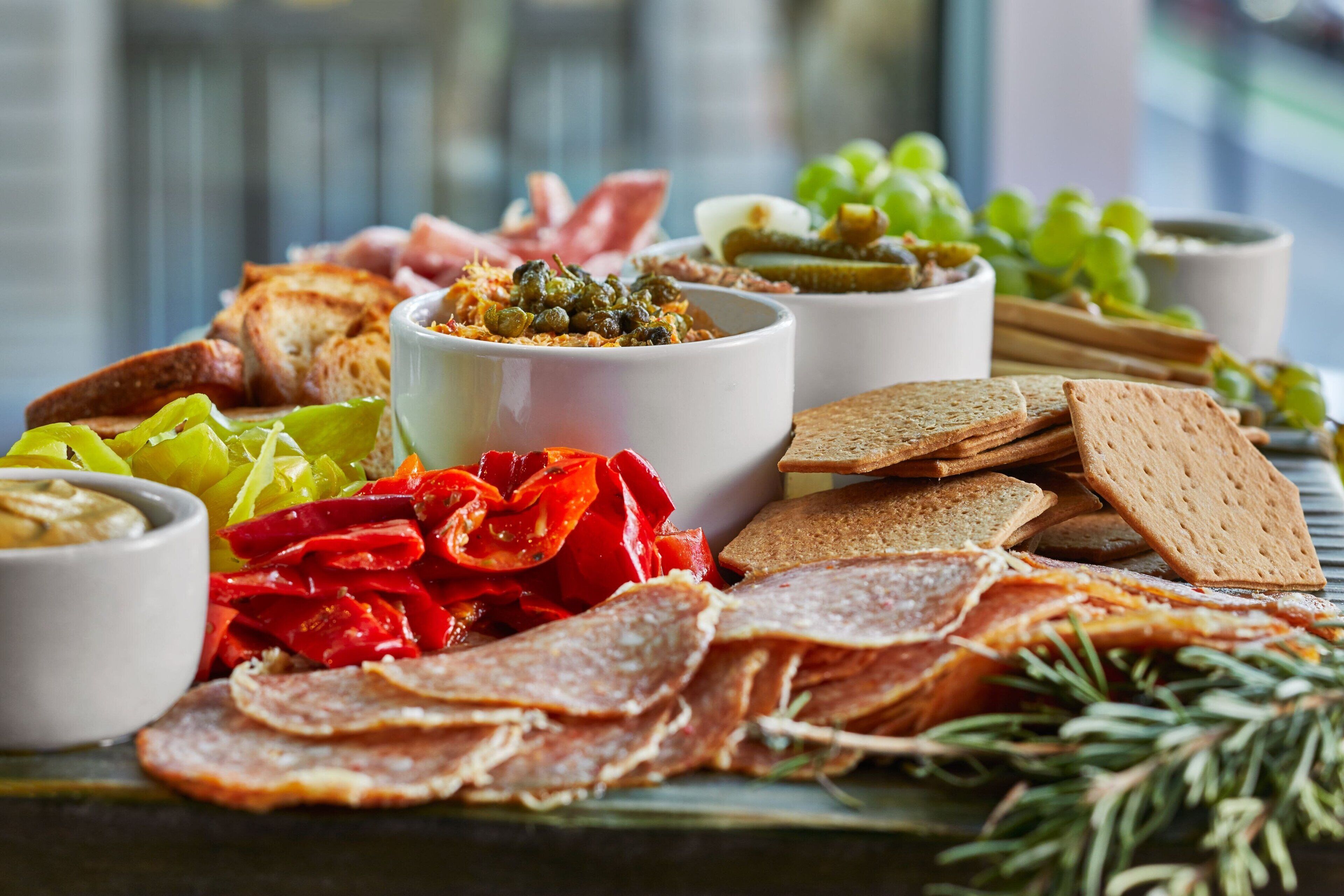 A charcuterie board with various meats, cheeses, and crackers.