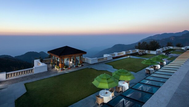 A rooftop terrace with a gazebo, outdoor seating, and a view of the mountains. - Jaypee Residency Manor (Dehradun)