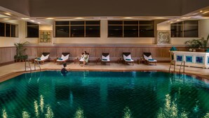 An indoor swimming pool with lounge chairs and a bar area. - Jaypee Residency Manor (Dehradun)