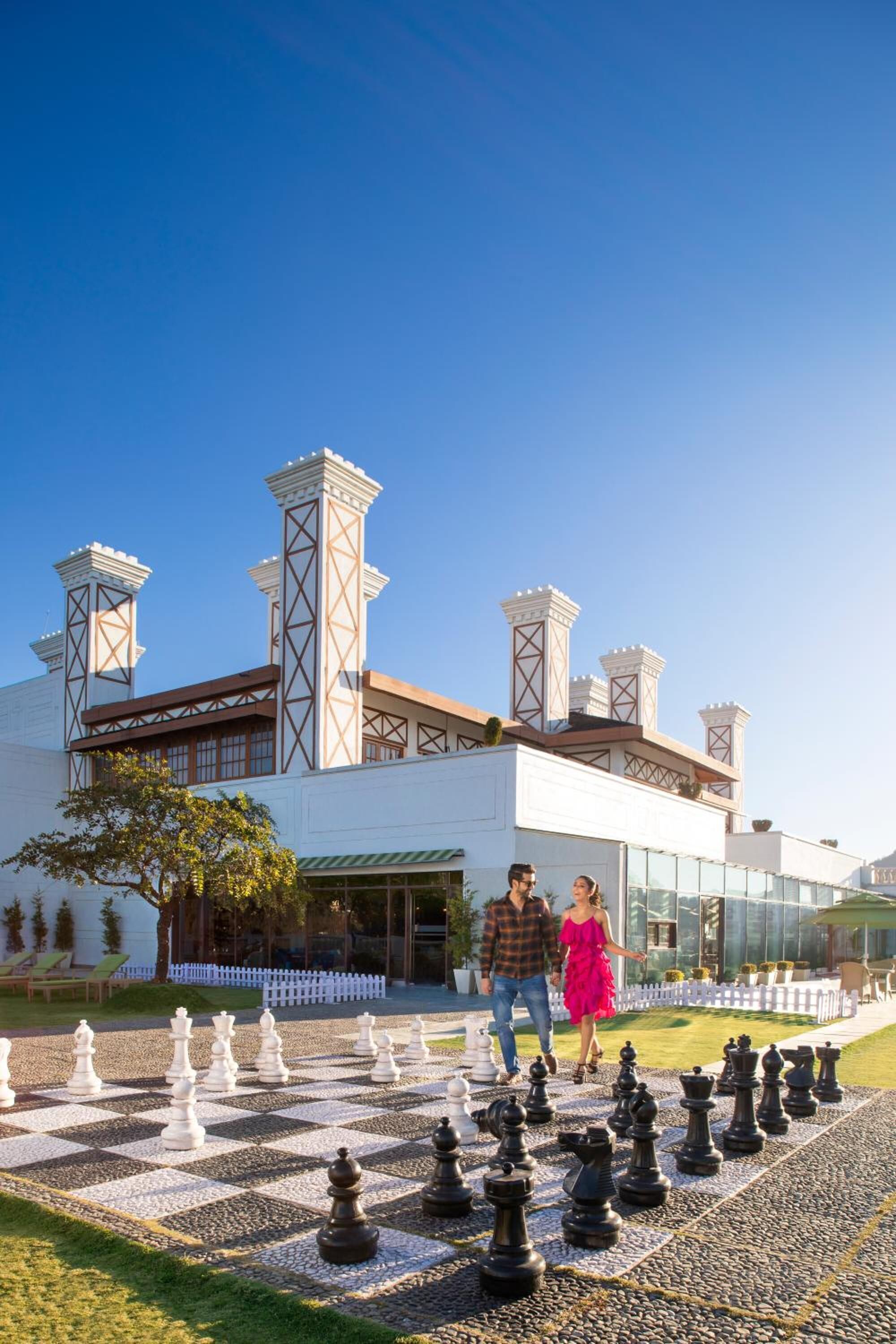 A chessboard set outdoors with a building in the background.