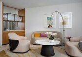 A modern living room with a sofa, two armchairs, a coffee table, and a floor lamp.